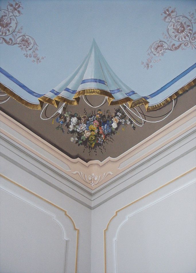 Particolare di soffitto di camera da letto: gli angoli del lenzuolo appeso teminano in un bouquet floreale